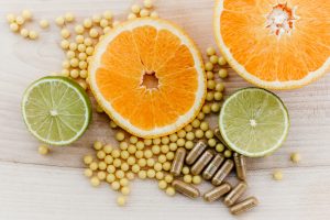 A birds-eye-view image of sliced oranges, limes, and supplements for gut healthj.